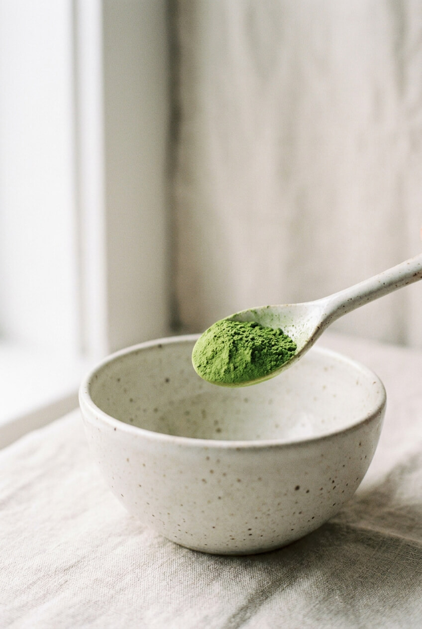 Fél teáskanál élénkzöld matcha por egy tál felett
